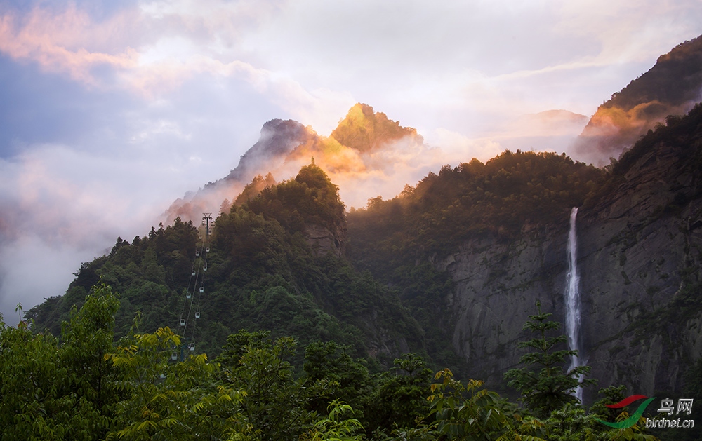 "长江南岸鄱湖畔,拔地庐山风景妍;峭壁陡崖飞瀑布,奇峰秀岭绕云烟"
