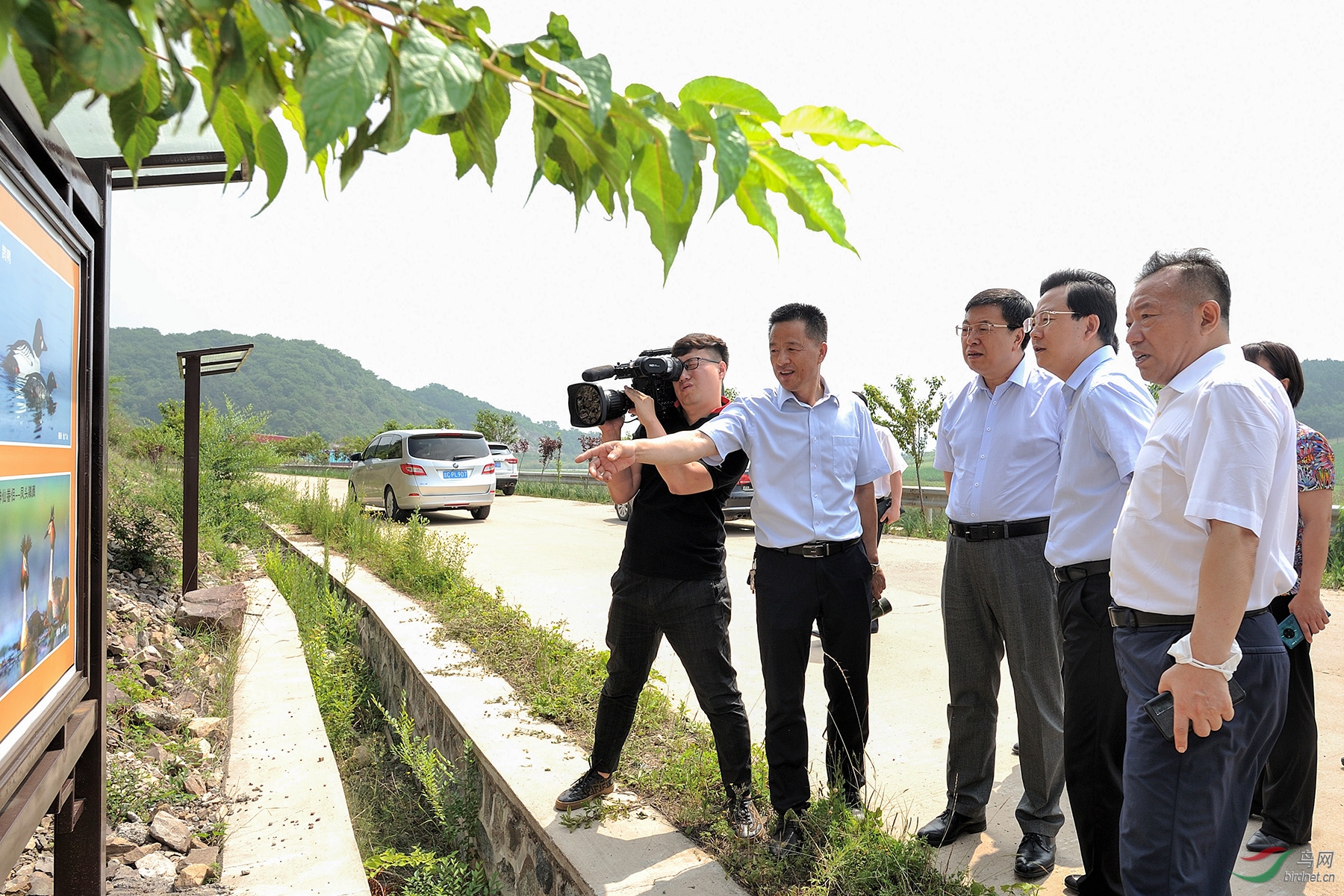 金广山向领导介绍生态鸟类画廊鸟类的名称和拍摄经历